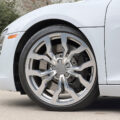Close-up of a silver Audi alloy wheel with drilled brake rotor visible through spokes.