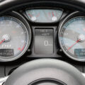 Close-up of a car instrument cluster with a tachometer on the left, speedometer on the right, and a central digital display showing 0 MPH and an odometer reading about 35,496 miles.